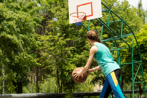 Obraz na płótnie Sporty slender teenager playing basketball w salonie
