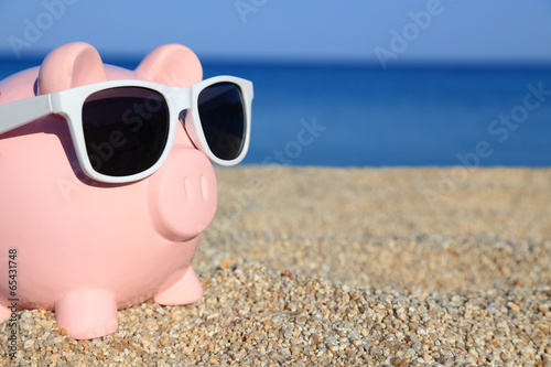 Summer piggy bank with sunglasses on the beach © viperagp