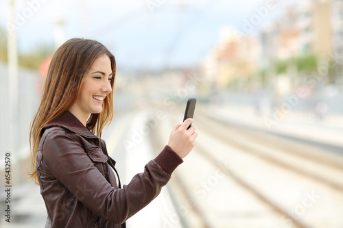 Woman browsing social media in a train station Free Download Woman browsing social media in a train station - GFXLoad