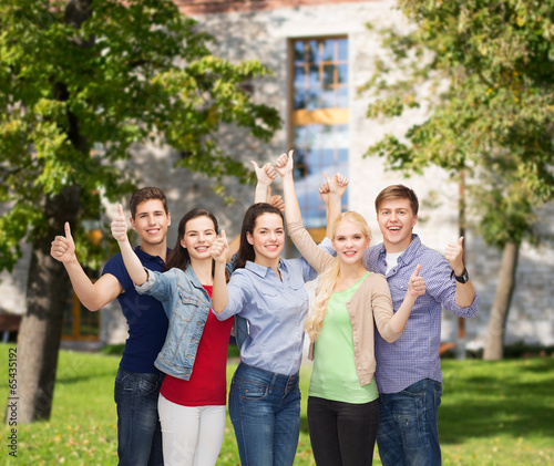 group of smiling students showing thumbs up