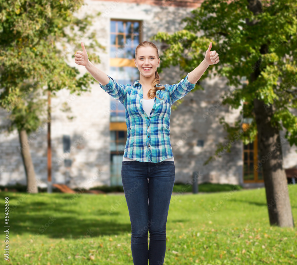 smiling girl in casual clothes showing thumbs up smiling girl in casual clothes showing thumbs up