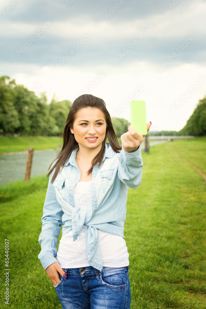 Teenage girl talking a selfie outdoors in park Teenage girl talking a selfie outdoors in park