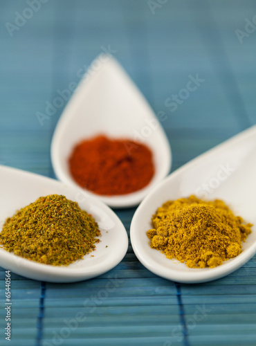 Dried ground spices in ceramic spoons