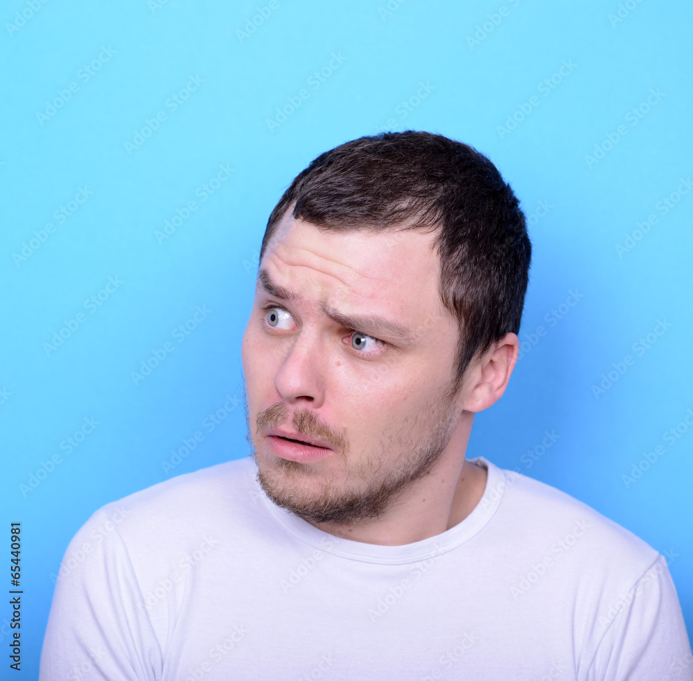 Portrait of man with dusgusted gesture against blue background Portrait of man with dusgusted gesture against blue background