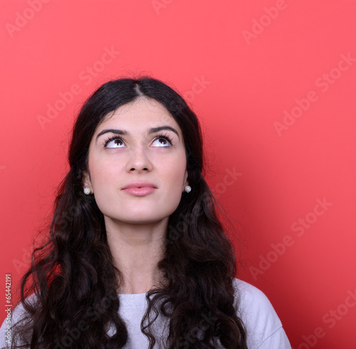 Portrait of beautiful girl looking up against red background © irishmaster