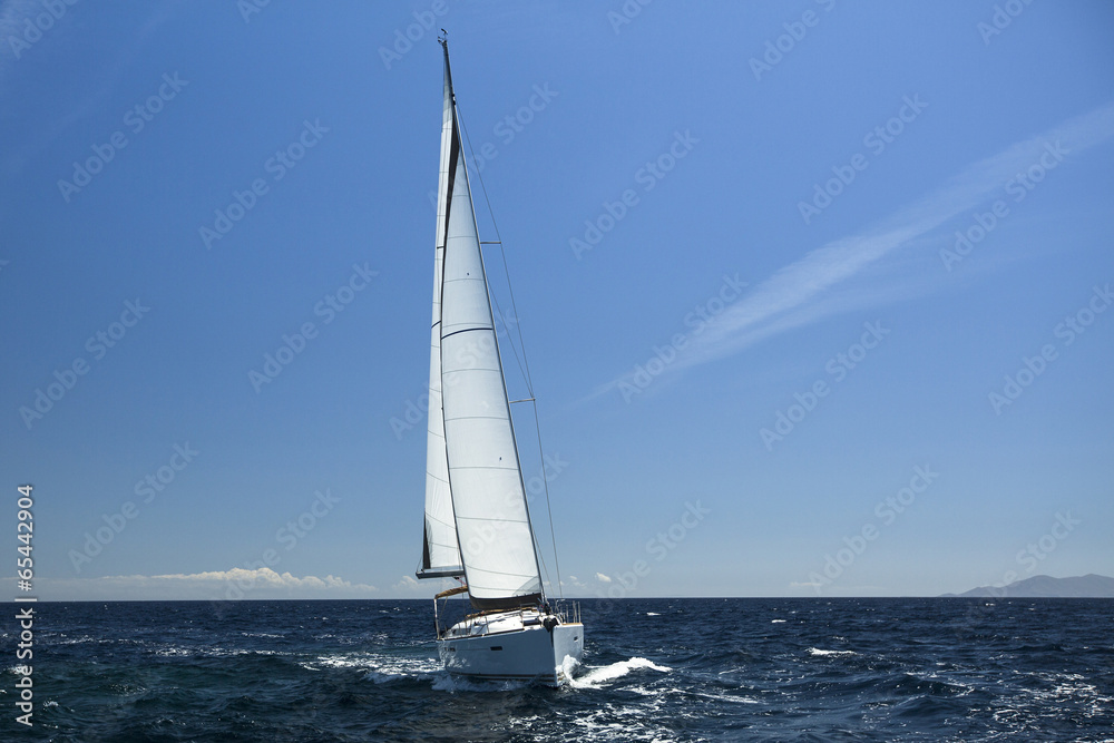 Sailing ship yachts with white sails in open sea.