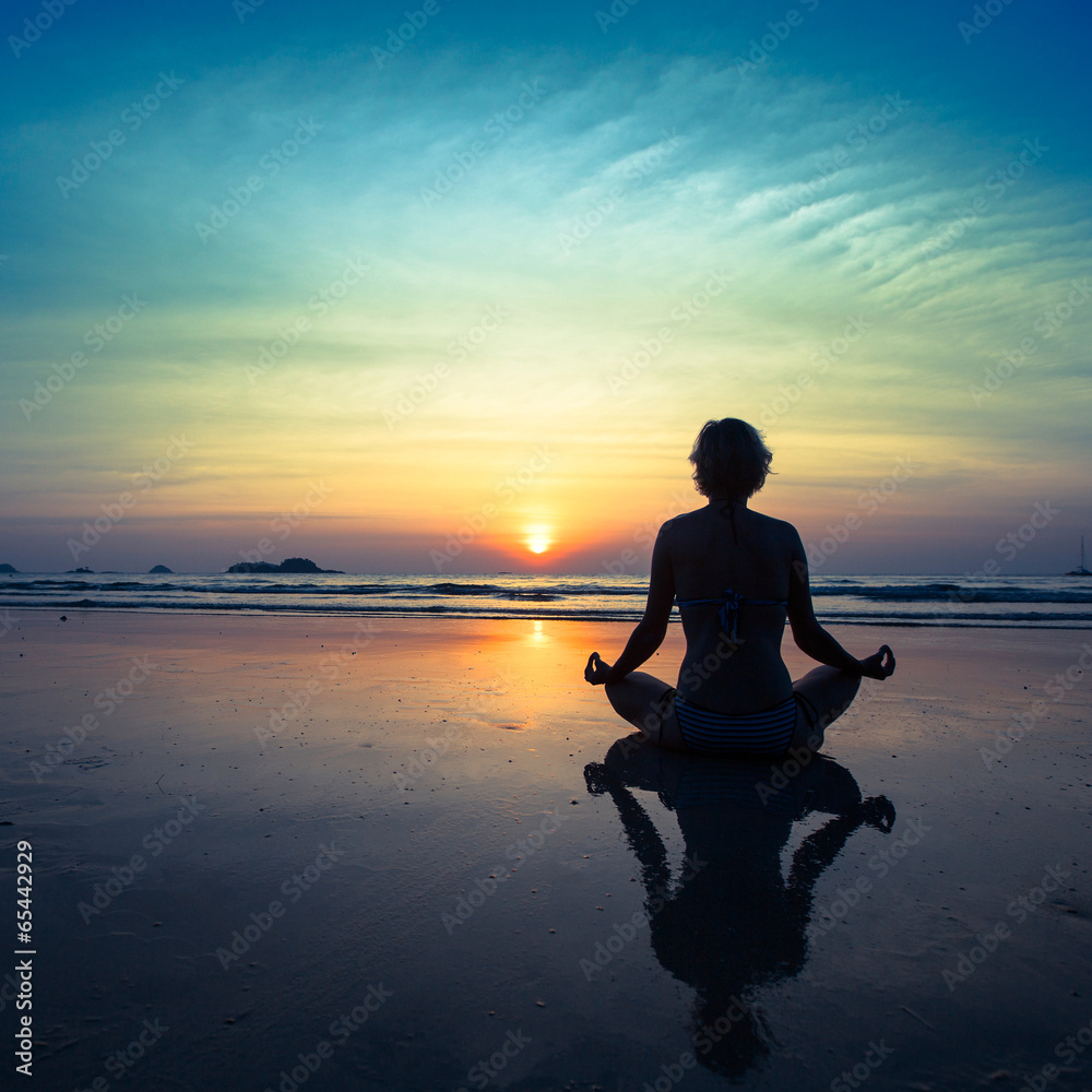 Yoga woman sitting on sea coast at sunset. Yoga woman sitting on sea coast at sunset.
