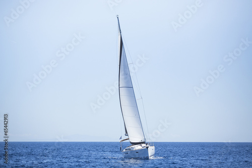 Sailing ship yachts with white sails in the open sea.