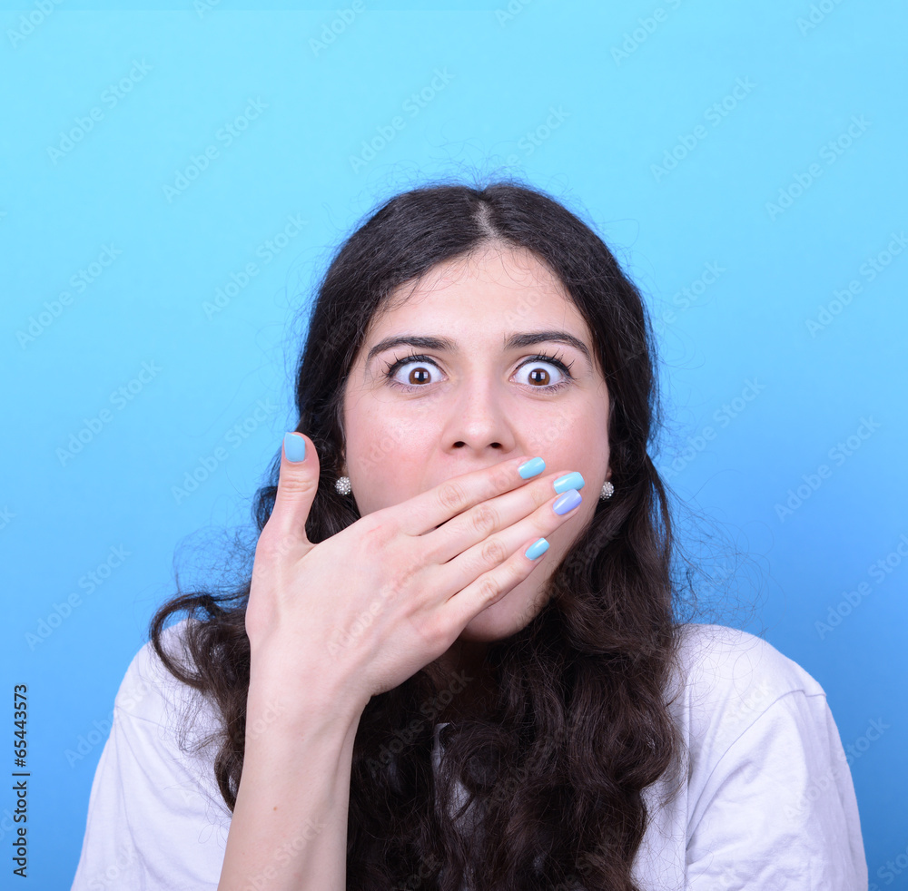 Portrait of girl with shock gesture looking up against blue back Portrait of girl with shock gesture looking up against blue back