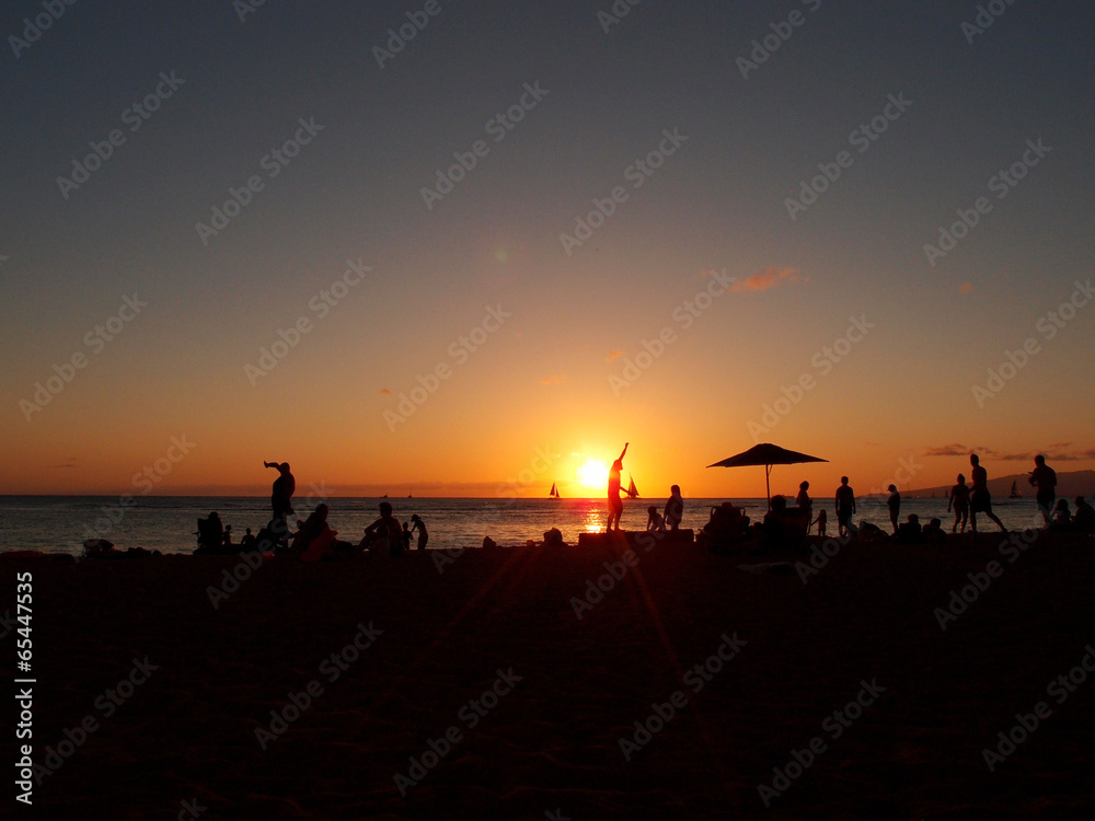 People watch dramatic Sunset on Kaimana Beach