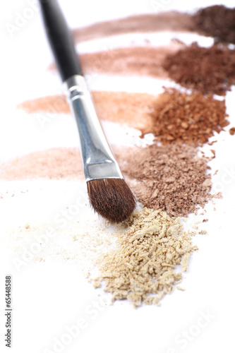 Crushed eyeshadow and professional make-up brush isolated © Africa Studio