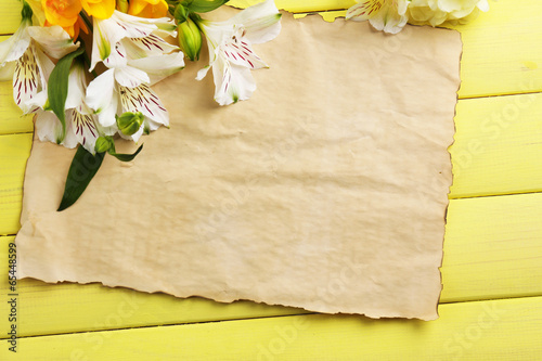 Beautiful Alstroemeria flowers and empty sheet on wooden table