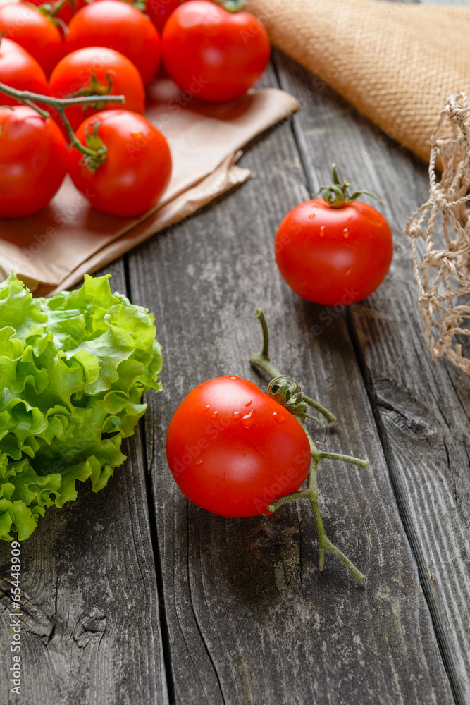 Tomatoes and salad on old grey wood