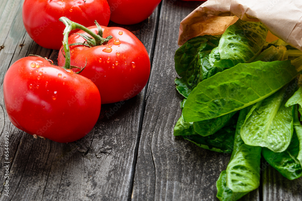 Tomatoes and salad on old grey wood