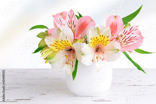 Fototapeta Naklejka Na Ścianę i Meble -  Alstroemeria flowers in vase on table on light background