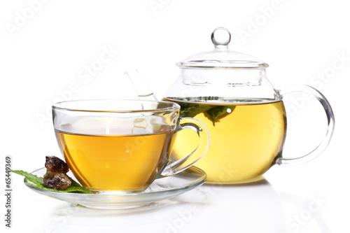 Composition of fresh mint tea in glass cup and teapot and brown