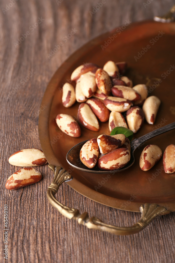 Fototapeta premium Tasty brasil nuts on salver, on wooden background