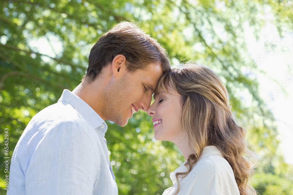 Attractive couple smiling at each other in the park Attractive couple smiling at each other in the park