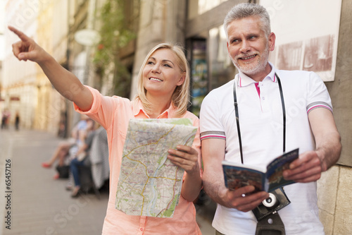 Bilde på lerret Mature tourist sightseeing city with map and guidebook