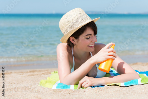 moderne junge frau trägt sonnenschutz auf