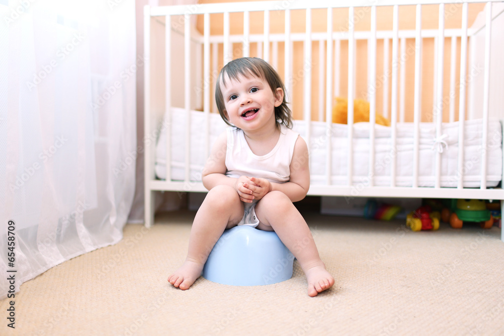 Fototapeta premium happy baby sitting on potty