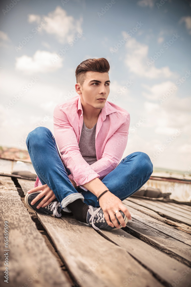 seated young casual man looking away