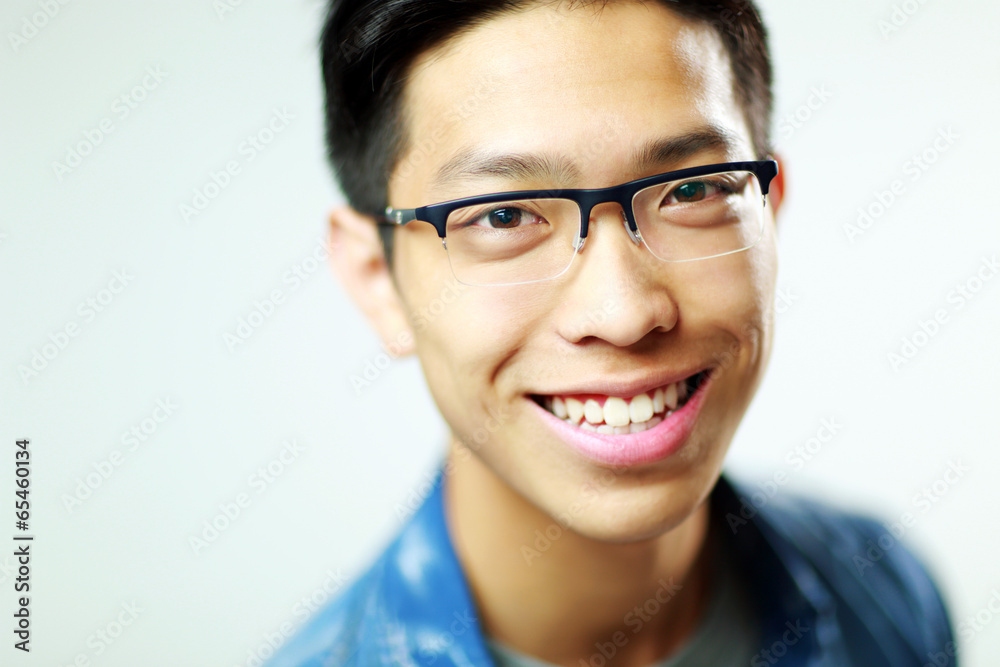 Closeup portrait of a young happy asian man on gray background Closeup portrait of a young happy asian man on gray background