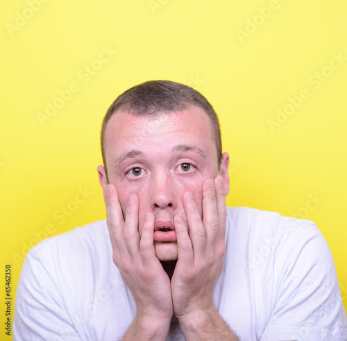 Portrait of desperate man against yellow background