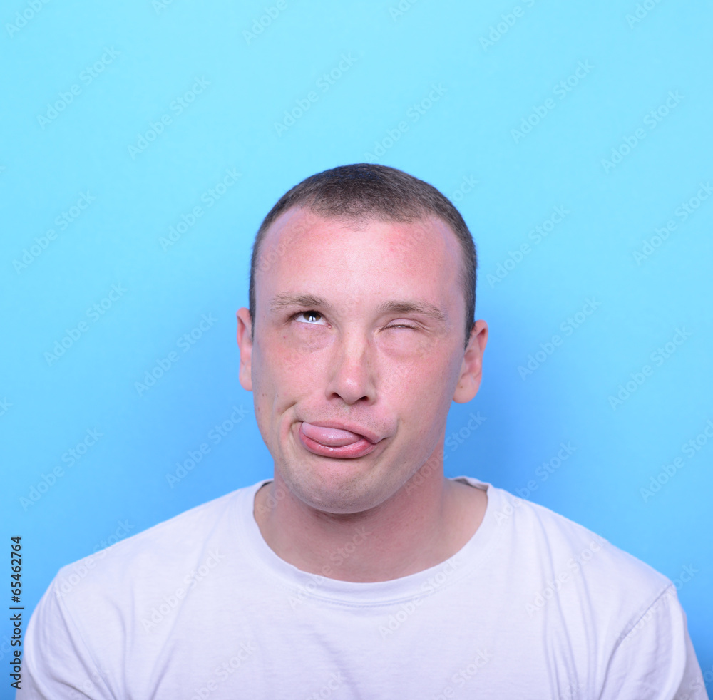 Fototapeta premium Portrait of girl with funny face against blue background