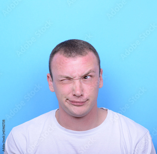 Portrait of girl with funny face against blue background