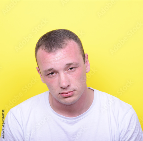 Portrait of tired man against yellow background