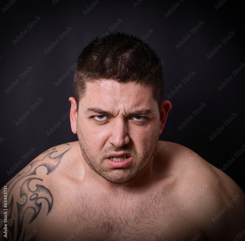 Portrait of angry man against dark background Portrait of angry man against dark background