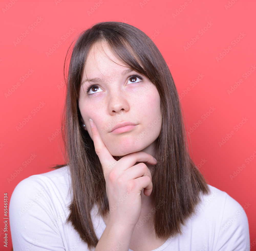 Portrait of beautiful girl looking above and thinking against re Portrait of beautiful girl looking above and thinking against re
