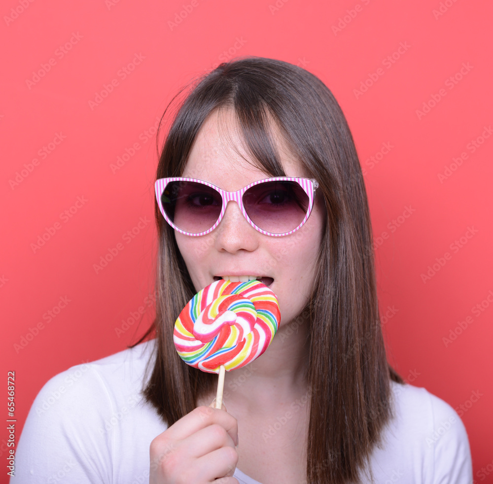 Portrait of woman with retro glasses and lollipop against red ba