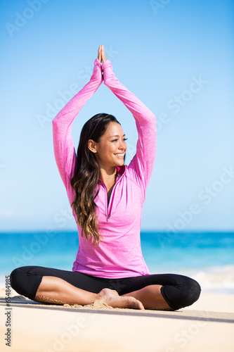 Boung woman in yoga pose at the beach