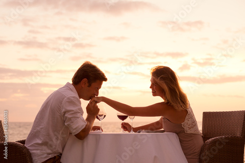 Couple enjoying romantic sunnset dinner on the beach photo