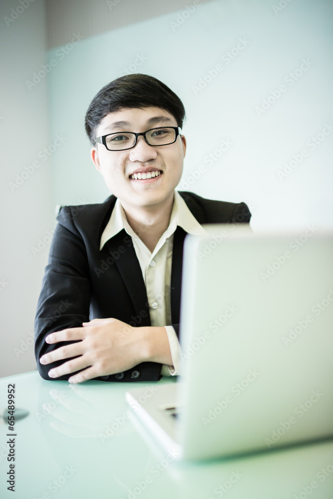 Young handsome man using laptop in his office Young handsome man using laptop in his office