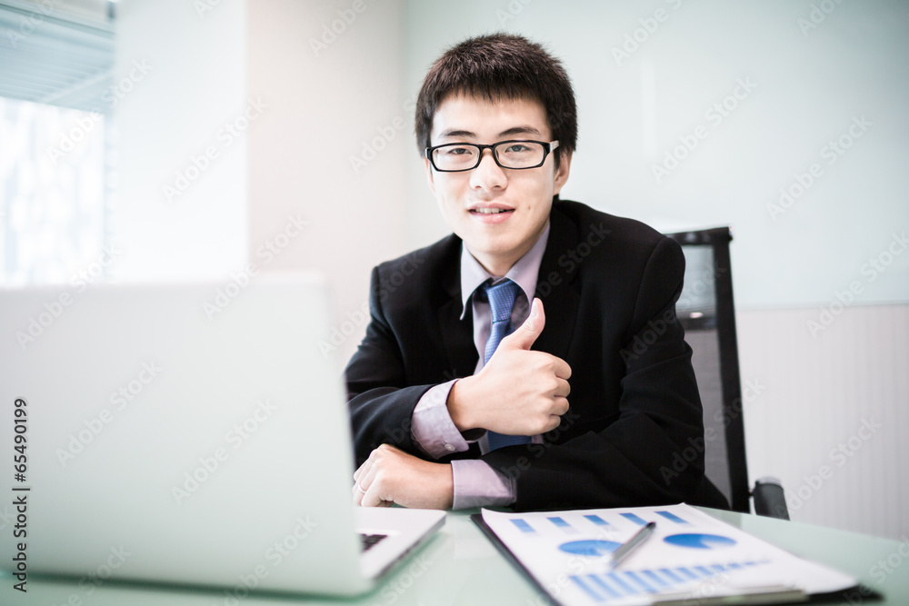 Young handsome man using laptop in his office Young handsome man using laptop in his office