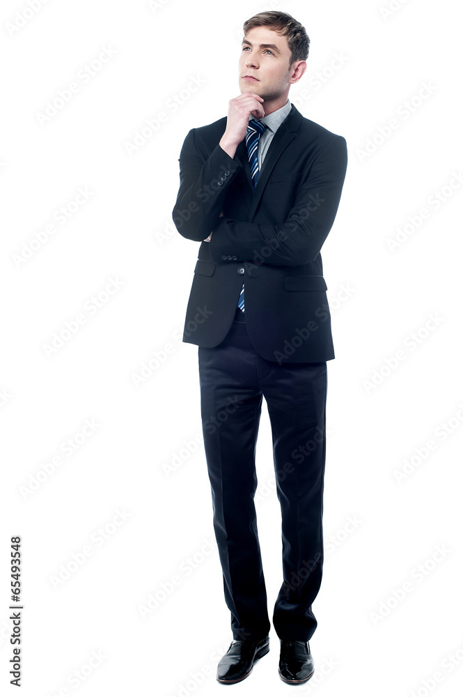 Thoughtful young business man looking up Thoughtful young business man looking up