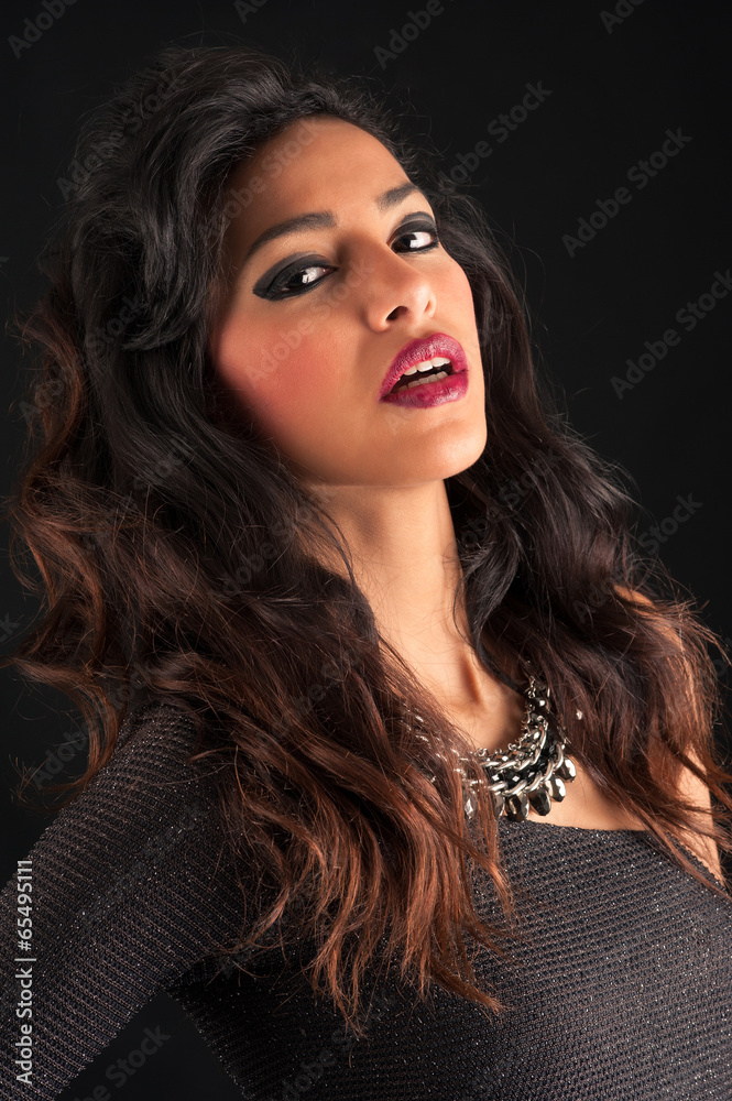 Sensual brunette woman portrait against black background.