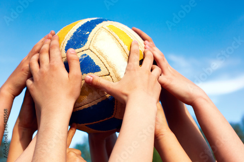 group of young people playing volleyball