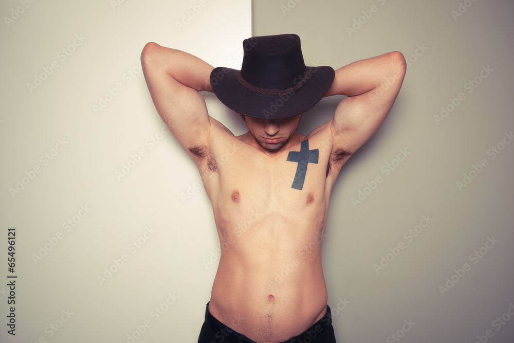 Shirtless young cowboy against dual colored background Shirtless young cowboy against dual colored background