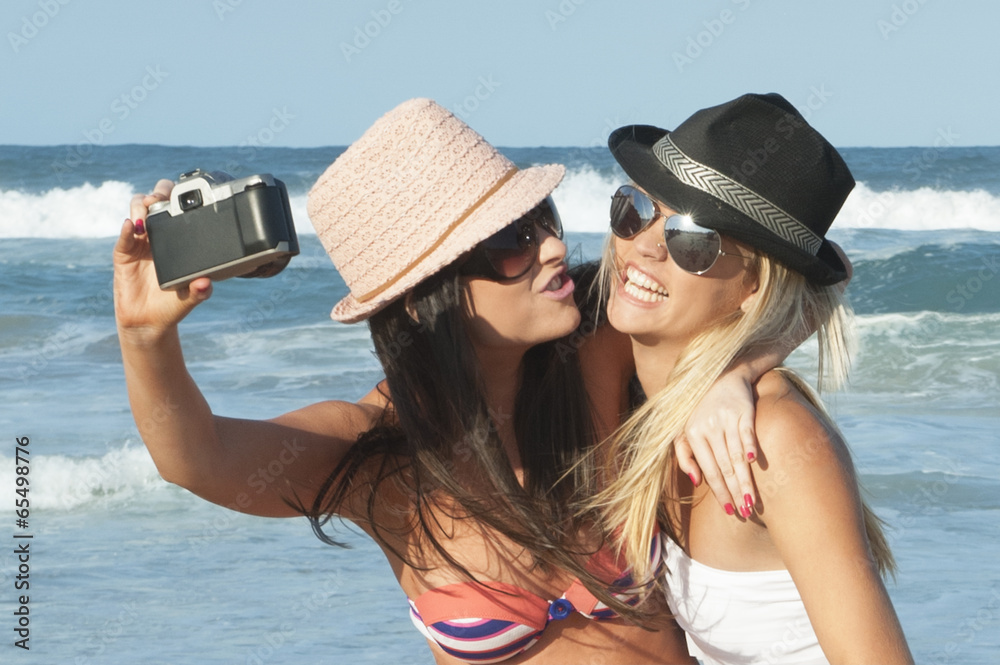 two attractive lesbian girls on the beach with film camera Stock Photo |  Adobe Stock