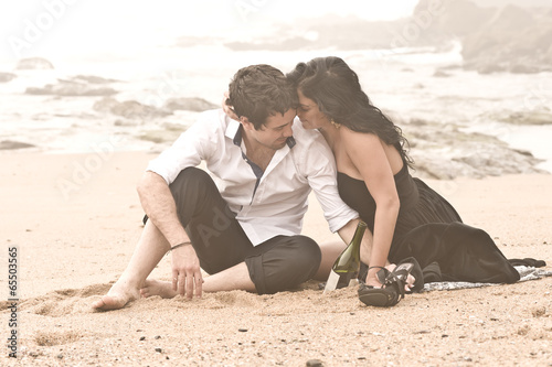 Young attractive couple sharing a moment on beach in the mist
