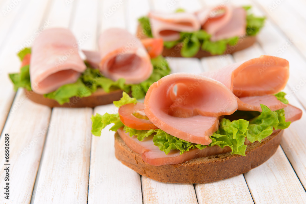 Delicious sandwiches with lettuce and ham on table close-up Delicious sandwiches with lettuce and ham on table close-up