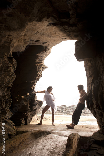 Young lovers flirting under arch at the beach