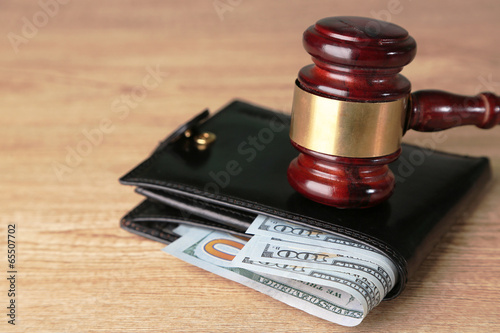 Gavel and money in wallet on wooden background photo