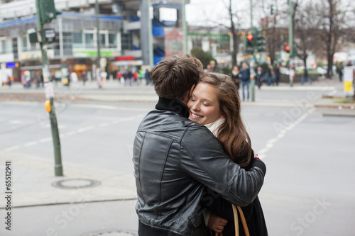 Couple In Jackets Embracing On Street Side