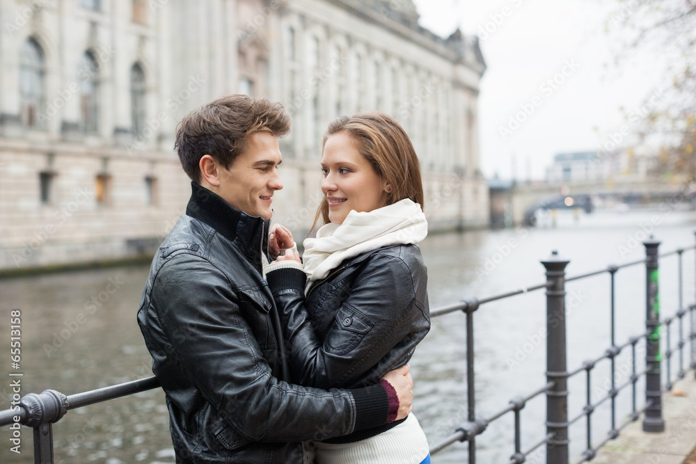 Romantic Couple In Jackets Embracing By Railing
