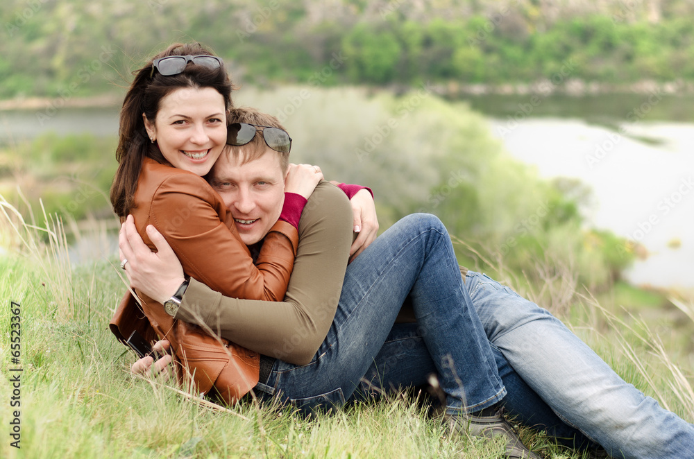 Loving young couple embracing on a hill top Loving young couple embracing on a hill top